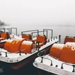 60a3d919-5c20-46e8-b5e1-f2c59f1c5997-orange-paddleboats-by-pier-calm-lake-captured-foggy-winter-day.jpg